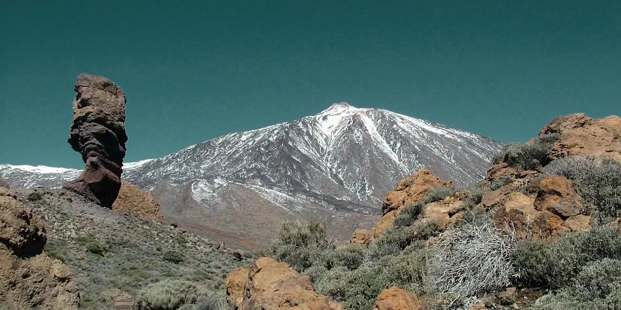 Le volcan du Teide enneigé au-dessus des roches volcaniques, à Tenerife