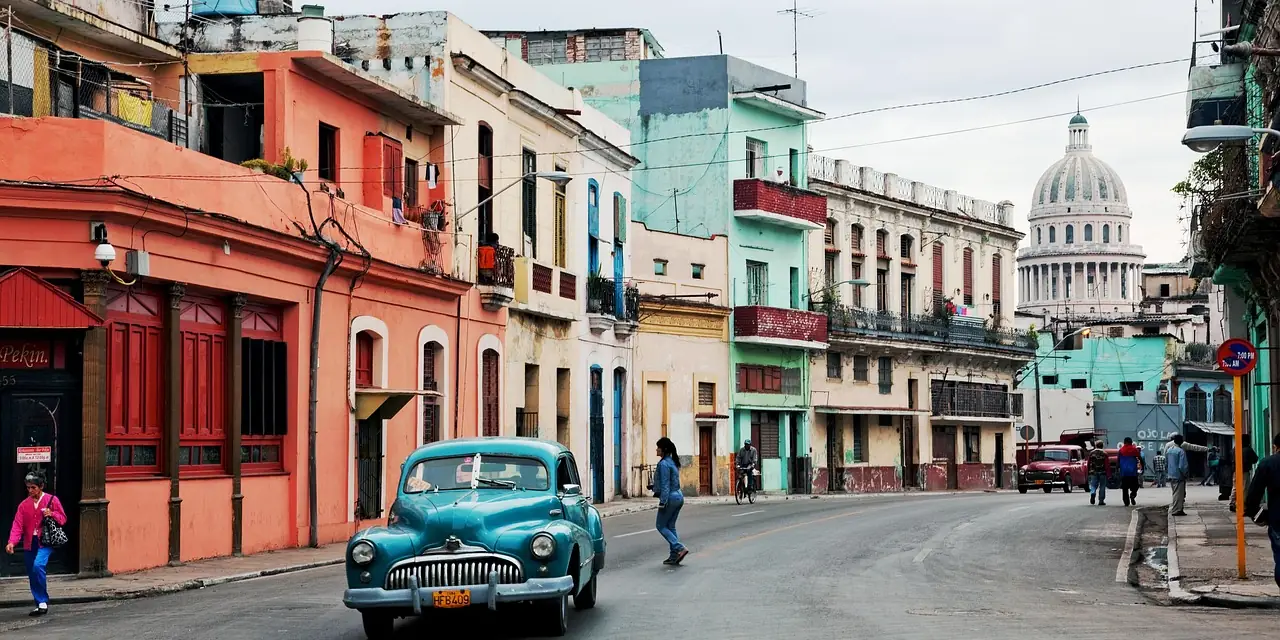 Voiture ancienne dans une rue colorée de La Havane, avec le Capitole au fond