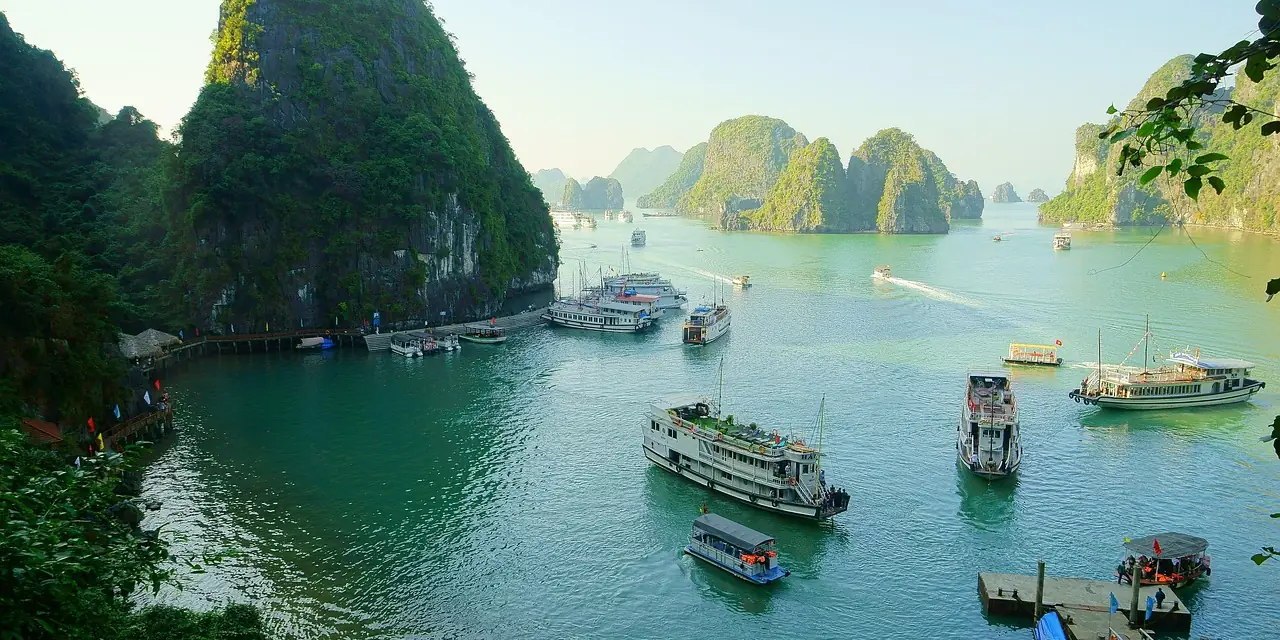 Bateaux entre les pitons calcaires de la baie d'Along, au Vietnam